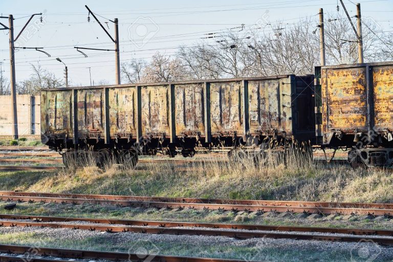 Old empty rusty train cars on rails in sunny day. Industrial crisis